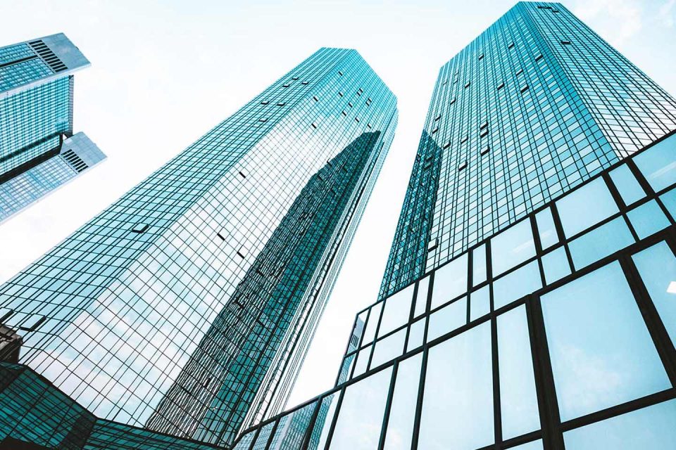 Skyscrapers pointing toward the sky reflecting the clouds above