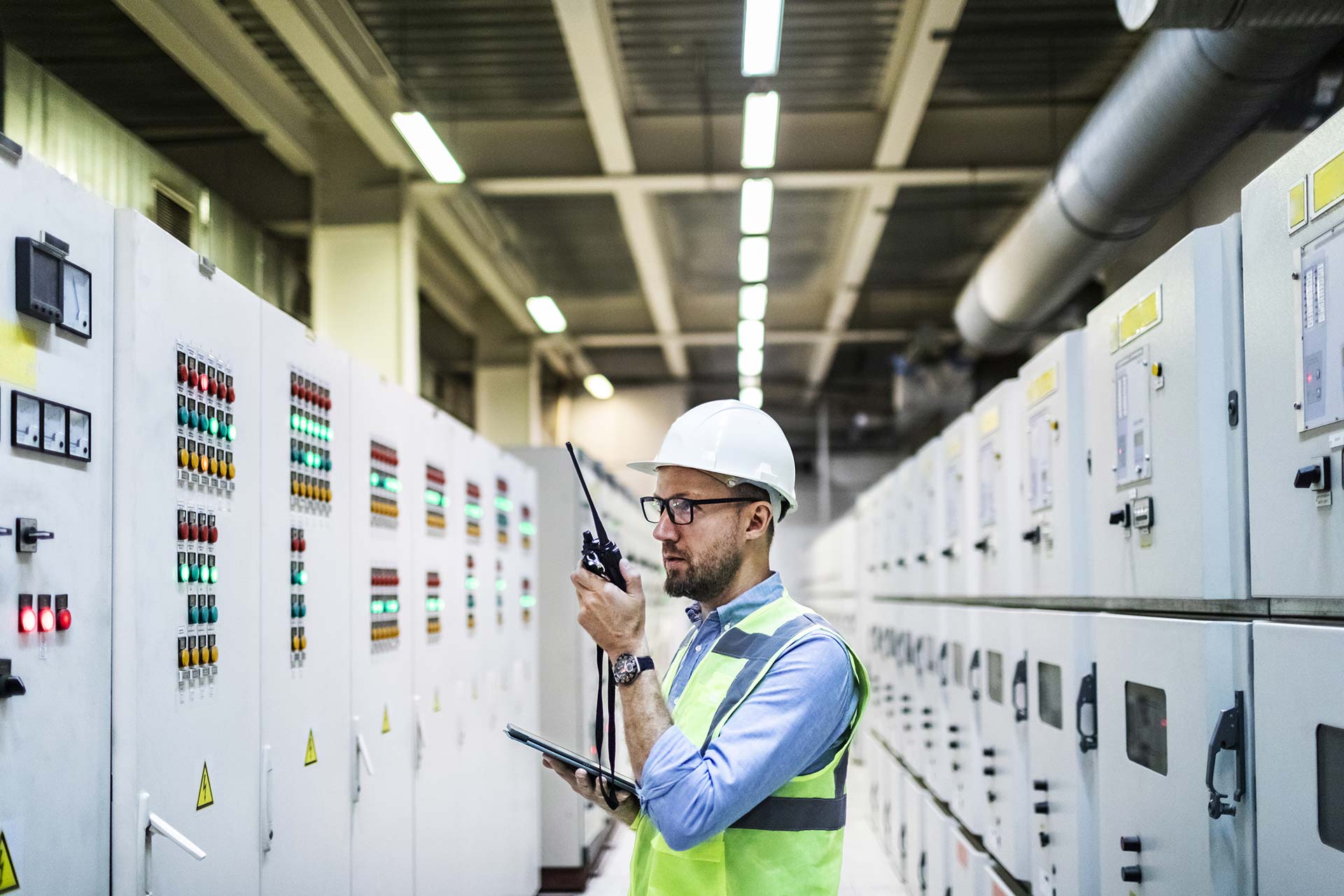 Man wearing a hard hat and neon vest conducting an energy audit for IonicBlue LLC